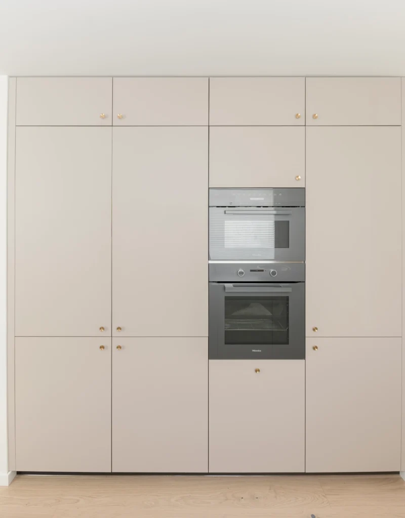 Frontal de columnas de cocina con electrodomésticos integrados y almacenaje vertical hasta el techo en cocina abierta en Vitoria.